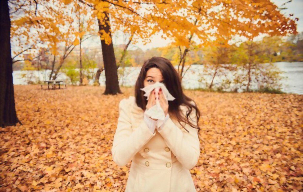 A young woman is sneezing due to fall allergies in Georgia.