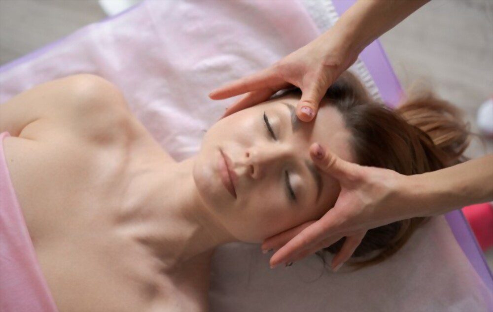Facial massage. Closeup young woman getting spa massage treatment at Karina Skin Care Greenvale.