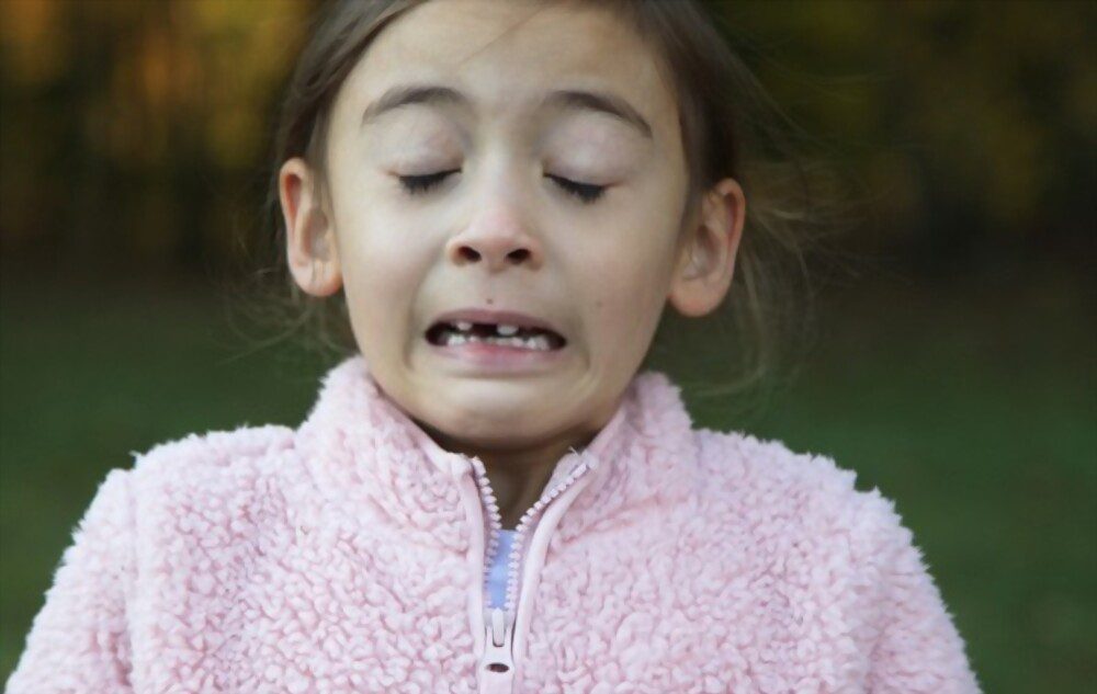 A girl having hay fever symptoms is sneezing and coughing.