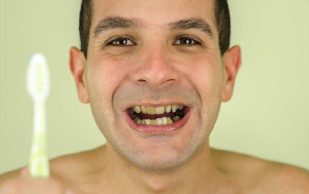 Ugly teeth picture - A man with a toothbrush and ugly teeth