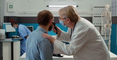 A doctor examining a patient ear, a concept of ENT And Allergy Of Delaware.