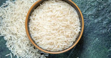A picture of raw rice in the bowl for the concept of rice allergy.